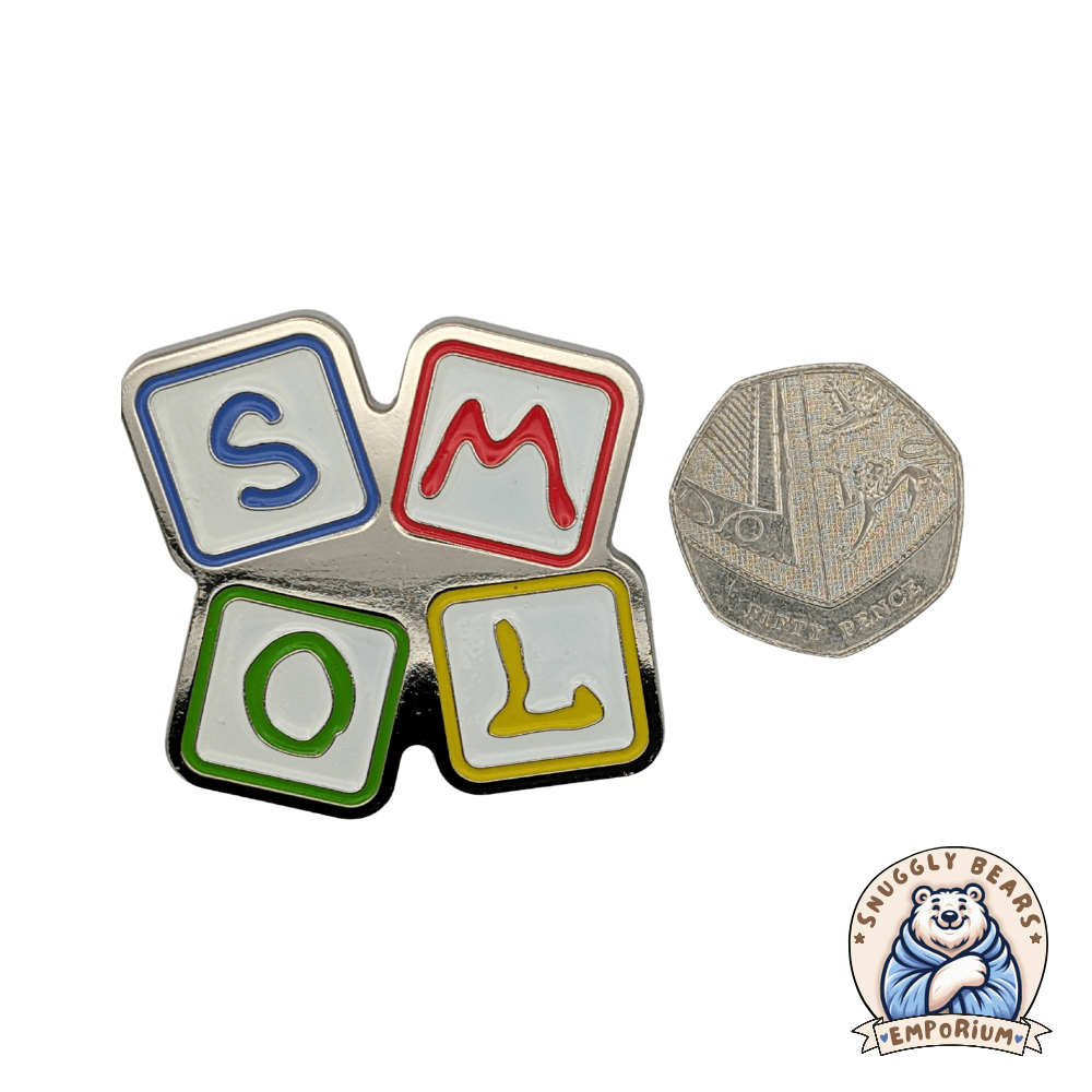 SMOL enamel pin badge featuring colorful alphabet blocks, compared to a 50p coin.