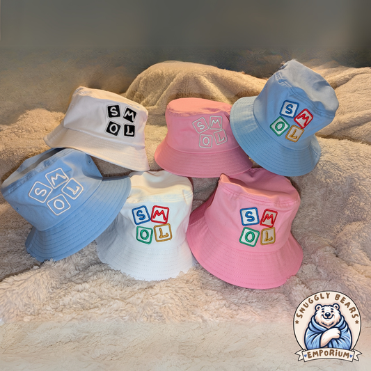 SMOL bucket hats in Blue, Pink and White with colorful block letters, perfect for sunny outdoor playdates and stylish everyday wear.
